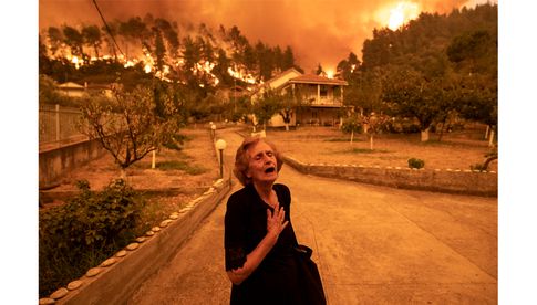 Gewinner - Europa - Einzelbeitrag: Foto: Waldbrand auf der Insel Evia; © Konstantinos Tsakalidis, for Bloomberg News Panayiota Kritsiopi weint, als der Waldbrand auf der Insel Evia ihr Haus im Dorf Gouves am 8. August 2021 erreicht.